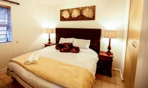 a bedroom with a bed with a dog laying on it at Secret Garden Guesthouse in Bloubergstrand +37 photos