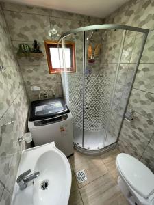 a bathroom with a shower and a toilet and a sink at Cabaña Rústica - Sector Pichares in Pichare