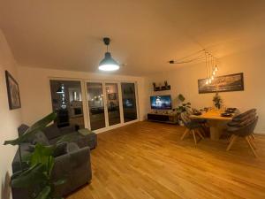 a living room with a couch and a table and a tv at Großzügiges Designer Apartment in Schönefeld