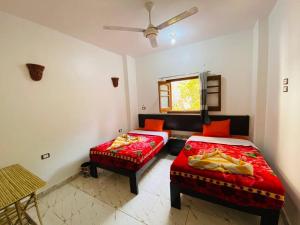 una camera da letto con due letti, un divano e una finestra di sunset guest house a Aswan