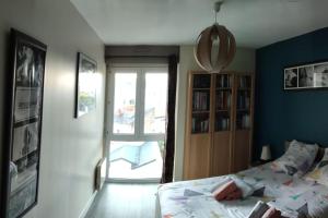 a bedroom with a bed and a sliding glass door at Grand T2 lumineux avec parking in Nantes