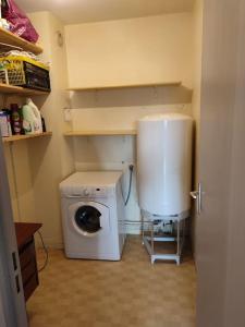 a small kitchen with a washing machine in a room at Grand T2 lumineux avec parking in Nantes