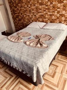 a bed with a blanket on it in a room at kitnet aconchegante in Ubatuba