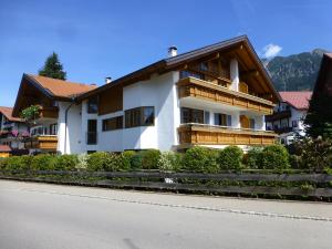 a large white building with a balcony on a street at Boutiqueferienwohnung Schnapshäusel in Oberstdorf