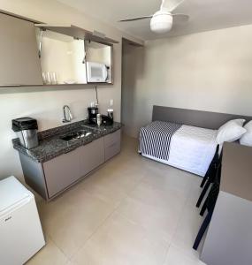 a kitchen with a bed and a sink in a room at Pousada Boutique do Lazer SP in Cabo Frio