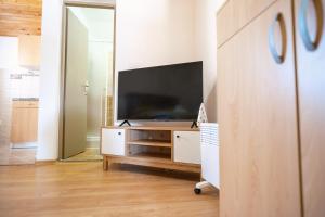 a living room with a flat screen tv on a dresser at Apartmani Biser Kupresa 4 in Kupres