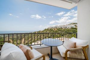 a balcony with a couch and a table at Samara 20 Luxury Apartments Spa Gym Pools Panoramic Views in Marbella