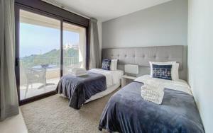 a bedroom with two beds and a balcony at Samara 20 Luxury Apartments Spa Gym Pools Panoramic Views in Marbella +37 photos
