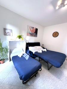 Dos camas en una habitación con sábanas azules. en Dreams Little Apartment - M5 Station - Near Center, en Milán