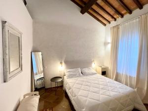 ein Schlafzimmer mit einem weißen Bett und einem Fenster in der Unterkunft Agriturismo Antica Corte in Valiano + 100 Fotos