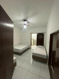 a room with two beds and a mirror at Casa Fátima in Aparecida +19 photos