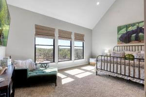 a bedroom with a bed and a couch and windows at Here Comes the Sun in Canyon Lake
