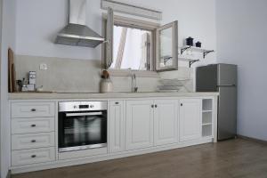 a kitchen with white cabinets and a sink and a window at Notus Villa in Chorto