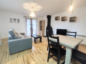 a living room with a table and a couch and a stove at CHECK-IN CASAS Ramonot in Benasque