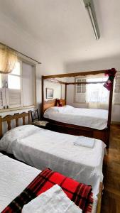 a bedroom with three beds and a window at Casa Diamantina in Diamantina