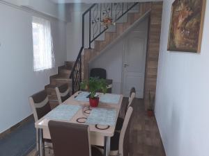 a dining room with a table with chairs and a staircase at Pensiunea Casa Lircă in Topliţa