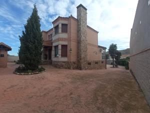 a large brick building with a tree in front of it at Casa Rural Vista Castillo in Almonacid de Toledo