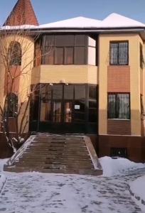 a building with snow in front of it at Достык Хостел in Almaty