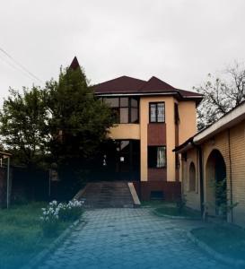 a large house with a driveway in front of it at Достык Хостел in Almaty +8 photos