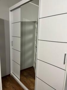 a closet with white drawers and a glass door at Mszczonów kawalerka Termy Suntago Deepspot in Mszczonów