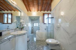 a bathroom with a toilet and a sink and a tub at Lussuoso appartamento vista Duomo in Florence +25 photos