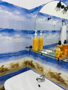 a bathroom with a sink with a picture of the ocean at Villa Mangofera in Galle