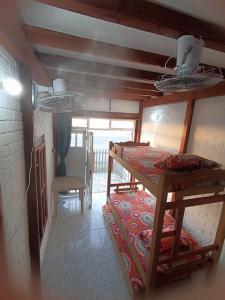 a room with two bunk beds and a table at Hostal Playa Descalzo in Cartagena de Indias