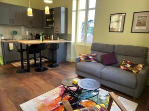 a living room with a couch and a kitchen at T2 standing de La tour jayan in Agen