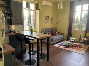 a kitchen and living room with a table and a couch at T2 standing de La tour jayan in Agen