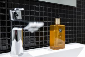 a bottle of soap sitting on a bathroom sink at Villa Nightsky -private location, sauna and jacuzzi in Rovaniemi +35 photos
