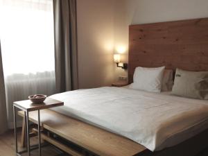 a bedroom with a large bed with a wooden headboard at Huber - Das Tiroler B&B in Oberperfuss +51 photos