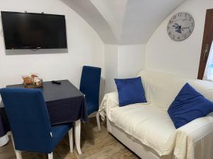 a living room with a table and a couch and a clock at Suite San Francesco in Grottaglie