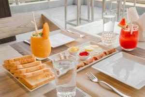 a table with a tray of breakfast foods and drinks at Ravo Hotel in Galle