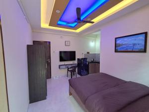 a bedroom with a bed and a ceiling with a blue light at Whispering Waves Luxury Homes in Majorda