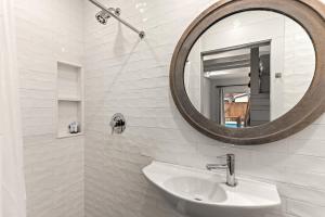 ein weißes Badezimmer mit Waschbecken und Spiegel in der Unterkunft 520 Beach, Unit 518 in Demere Park + 12 Fotos