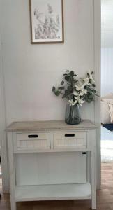 une table blanche avec un vase de fleurs dessus dans l'établissement Vinterhus nära Romme Alpin, à Borlänge