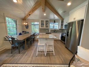 a kitchen with a table and chairs and a refrigerator at Tree Spirit Retreat - 4310 Third Street in Saint Simons Island