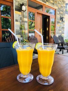 two glasses of orange juice sitting on a wooden table at Simplex Sea Place in Tangalle +35 photos
