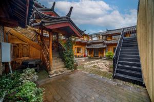 a courtyard of an asian house with stairs at Walk Together Hotel in Lijiang