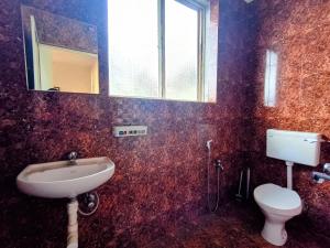 a bathroom with a sink and a toilet at GS Home on the Bay - Sea & forest view glass studio in Vagator +66 photos