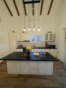 a kitchen with a large island with a black counter top at Country House Lištani-renta quad in Livno