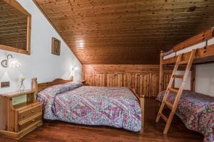 une chambre avec deux lits et une échelle dans l'établissement Appartamento Sellaronda, à Arabba