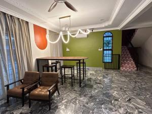 a room with a table and chairs and a staircase at Piano homestay in Alor Setar