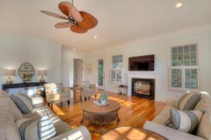 a living room with white furniture and a fireplace at Watermark - 637 Demere Way in Demere Park