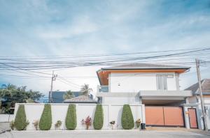 a white house with trees in front of it at Luxury 4 Bedroom Beach House in Ban Saiyuan (1)