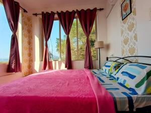 - une chambre avec un lit rose et une fenêtre dans l'établissement GS Home on the Bay - Super Sea view glass studio apartment, à Vagator