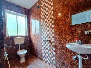 a bathroom with a toilet and a sink at GS Home on the Bay - Super Sea view glass studio apartment in Vagator +50 photos