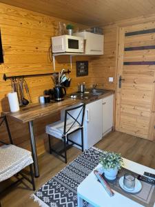 a small kitchen with a table and a microwave at Mały Karmelowy Domek in Stężyca +4 photos