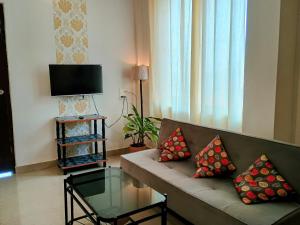 a living room with a couch and a glass table at GS Home on the Bay - Super Sea view glass studio apartment in Vagator