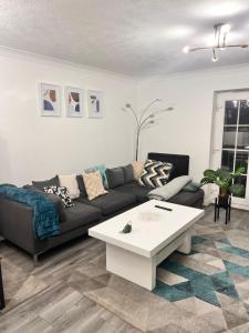 een woonkamer met een bank en een salontafel bij Lovely tidy and well decorated en-suite king sized bedroom in a shared 2 bedroom flat in Belle Isle +1 foto